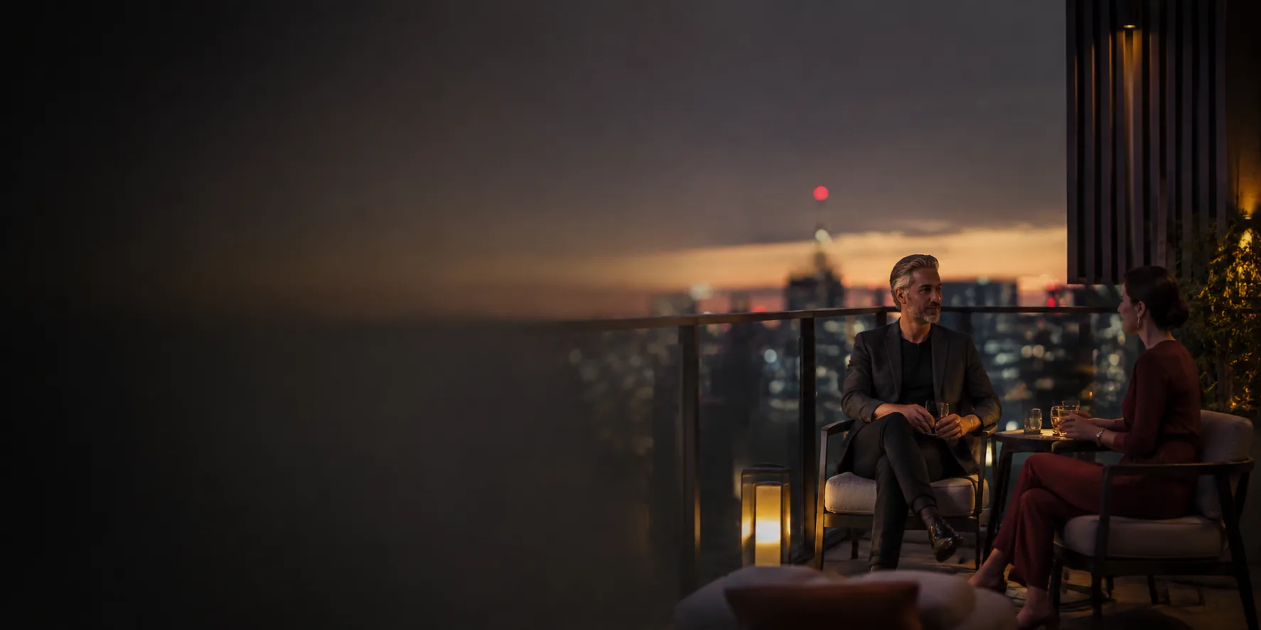A couple sharing wine on an Adelaide rooftop at dusk