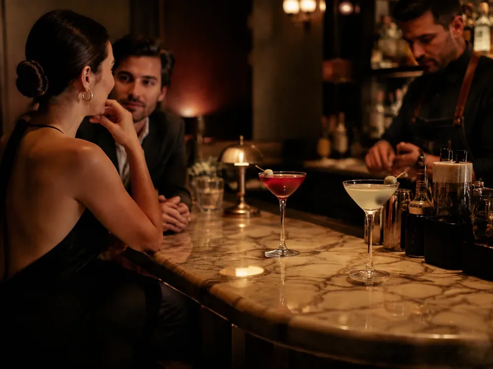 Two people having a considered conversation in an elegant cocktail bar